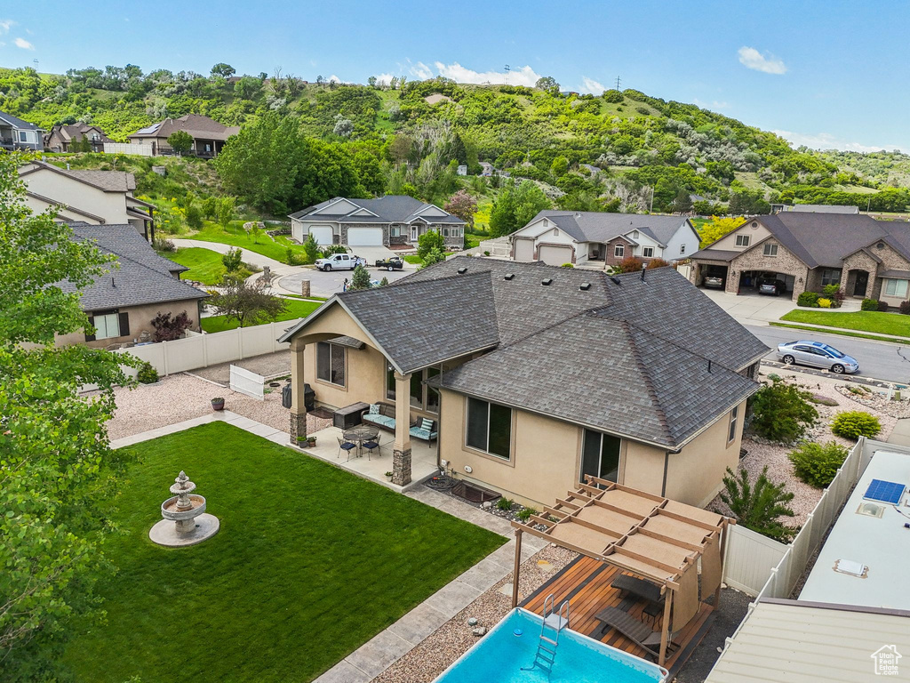 Back of house with stucco siding, roof with shingles, a residential view, and a patio area