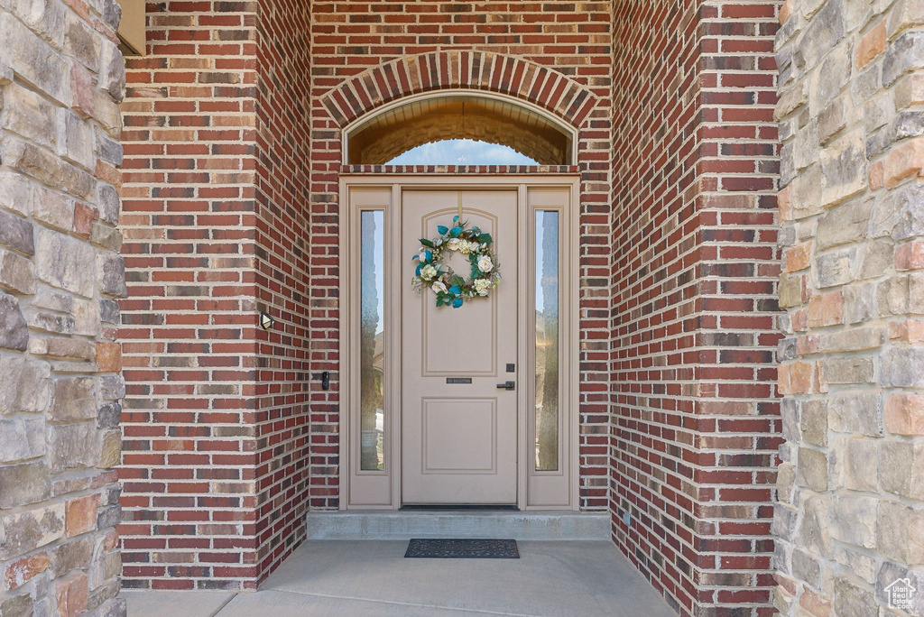 View of exterior entry featuring brick siding