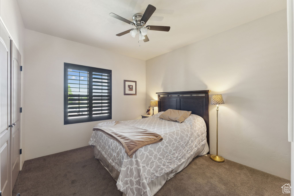 Carpeted bedroom featuring ceiling fan