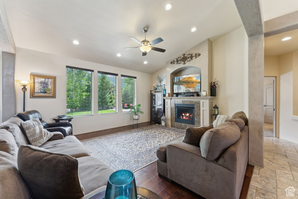 Living room with a ceiling fan, a high end fireplace, recessed lighting, and vaulted ceiling