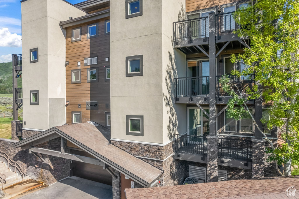 View of apartment building / complex featuring asphalt driveway and an attached garage