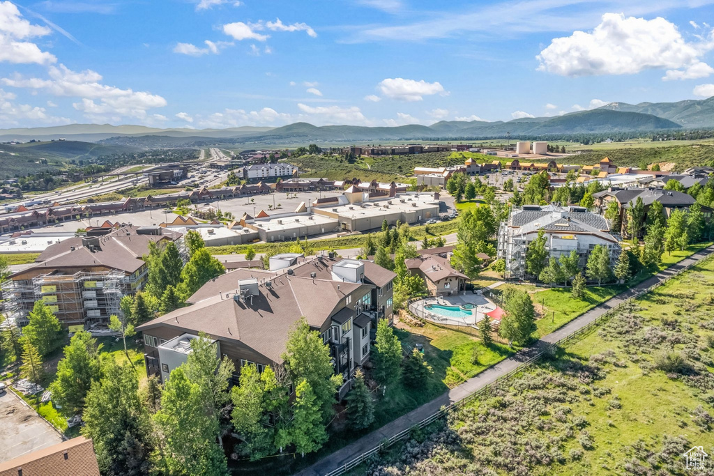 Aerial view of residential area featuring mountains and a pool area