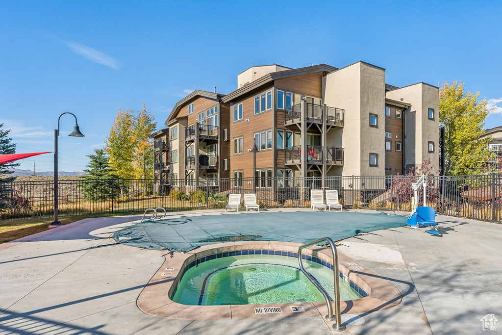 Community pool with a hot tub and a patio area