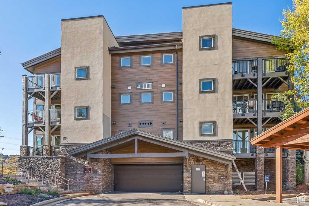 View of apartment building / complex with concrete driveway and an attached garage