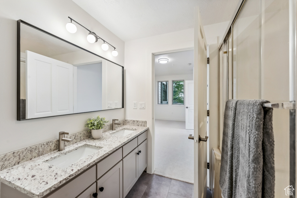 Bathroom with double vanity and tile patterned flooring
