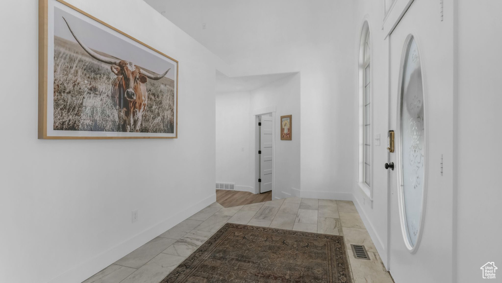 Hallway with marble finish flooring and baseboards