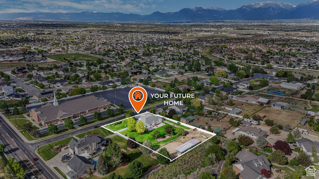 Aerial overview of property's location with property parcel outlined, a mountain backdrop, and nearby suburban area