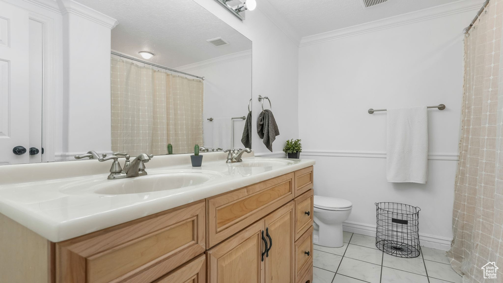 Full bath featuring toilet, crown molding, double vanity, tile patterned flooring, and a shower with curtain