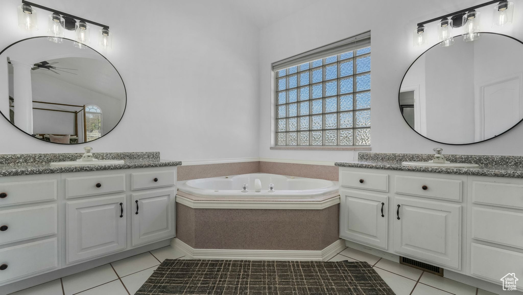 Full bathroom with tile patterned flooring, a ceiling fan, a garden tub, and two vanities