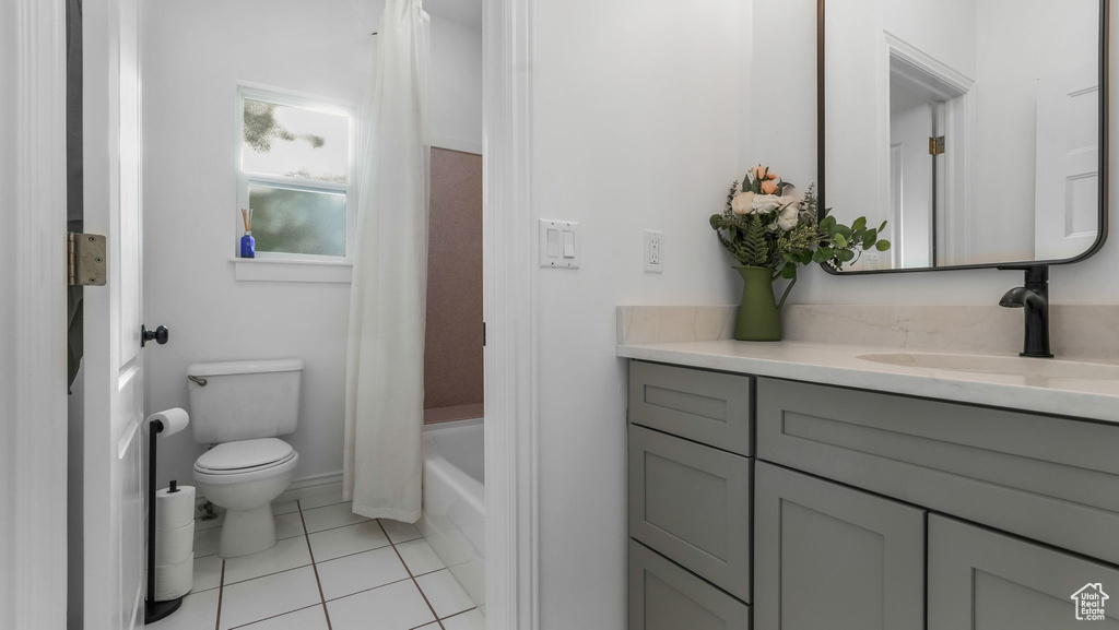 Full bathroom featuring toilet, vanity, and tile patterned floors