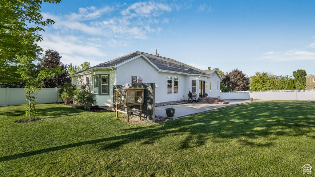 Back of property with stucco siding and a patio