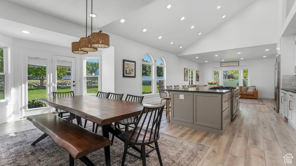 Dining room with light wood-type flooring, recessed lighting, high vaulted ceiling, and baseboards