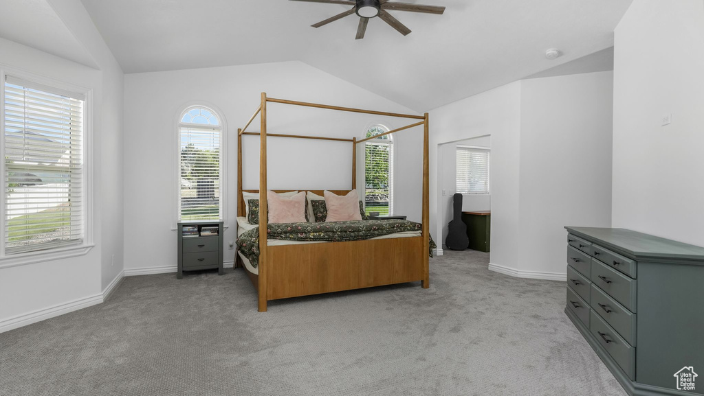 Bedroom featuring lofted ceiling, light carpet, baseboards, and a ceiling fan