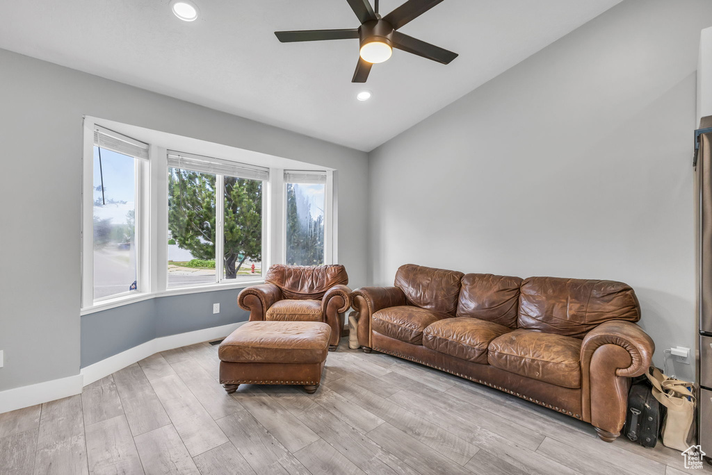 Living area with vaulted ceiling, a ceiling fan, wood finished floors, recessed lighting, and baseboards