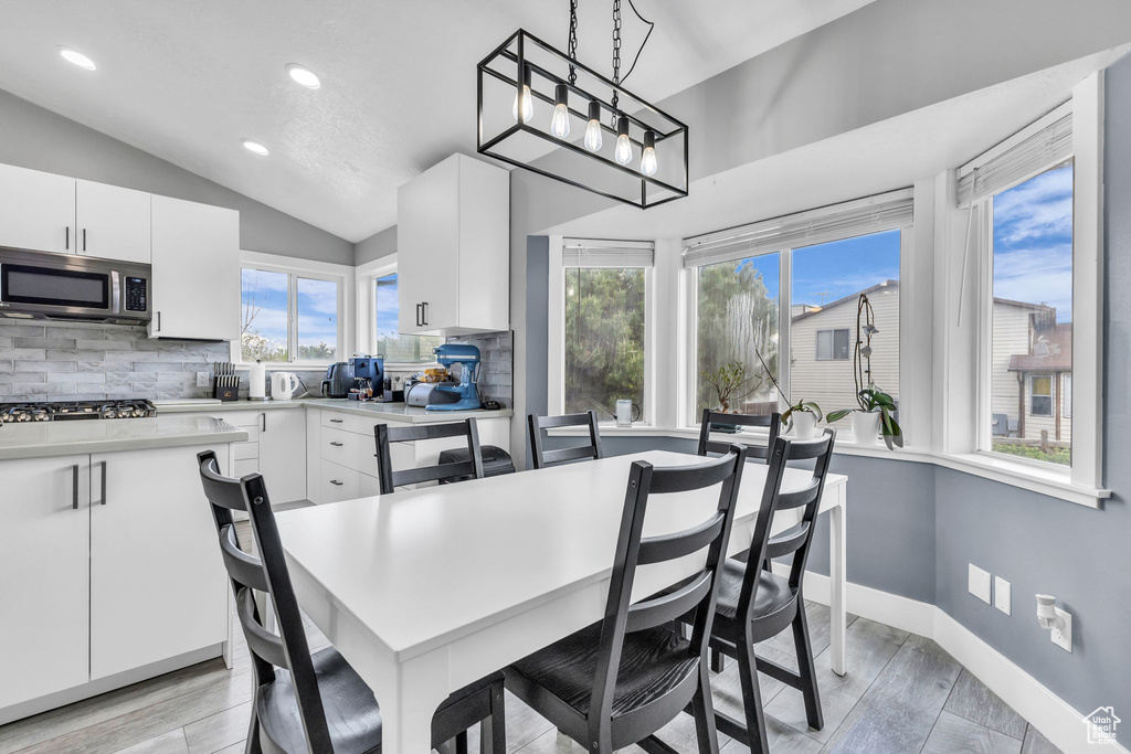 Dining room featuring vaulted ceiling, recessed lighting, light wood finished floors, and baseboards