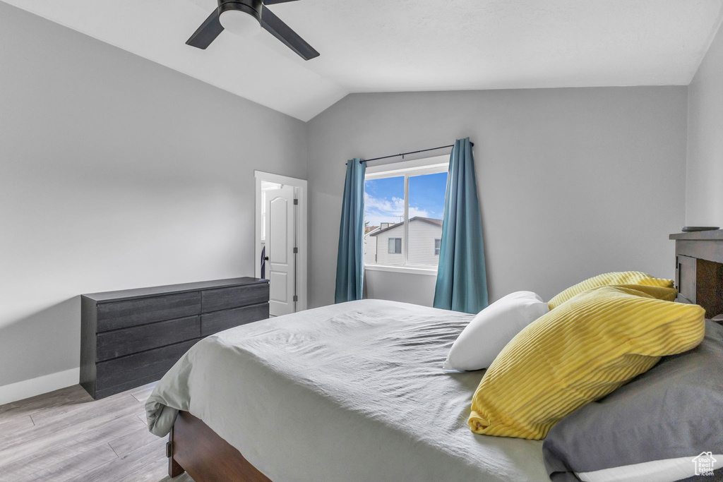 Bedroom featuring wood finished floors, baseboards, vaulted ceiling, and ceiling fan