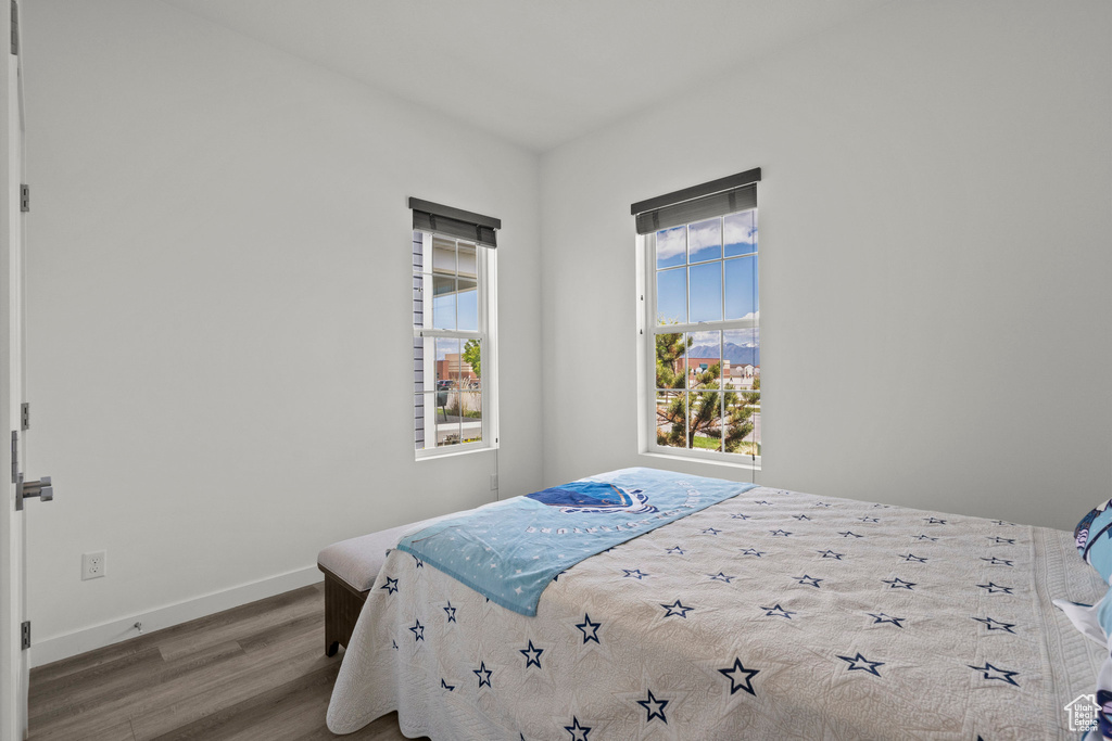 Bedroom with wood finished floors and baseboards