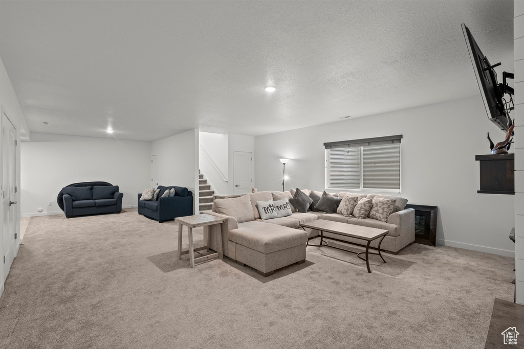 Living area with stairs, carpet floors, and baseboards