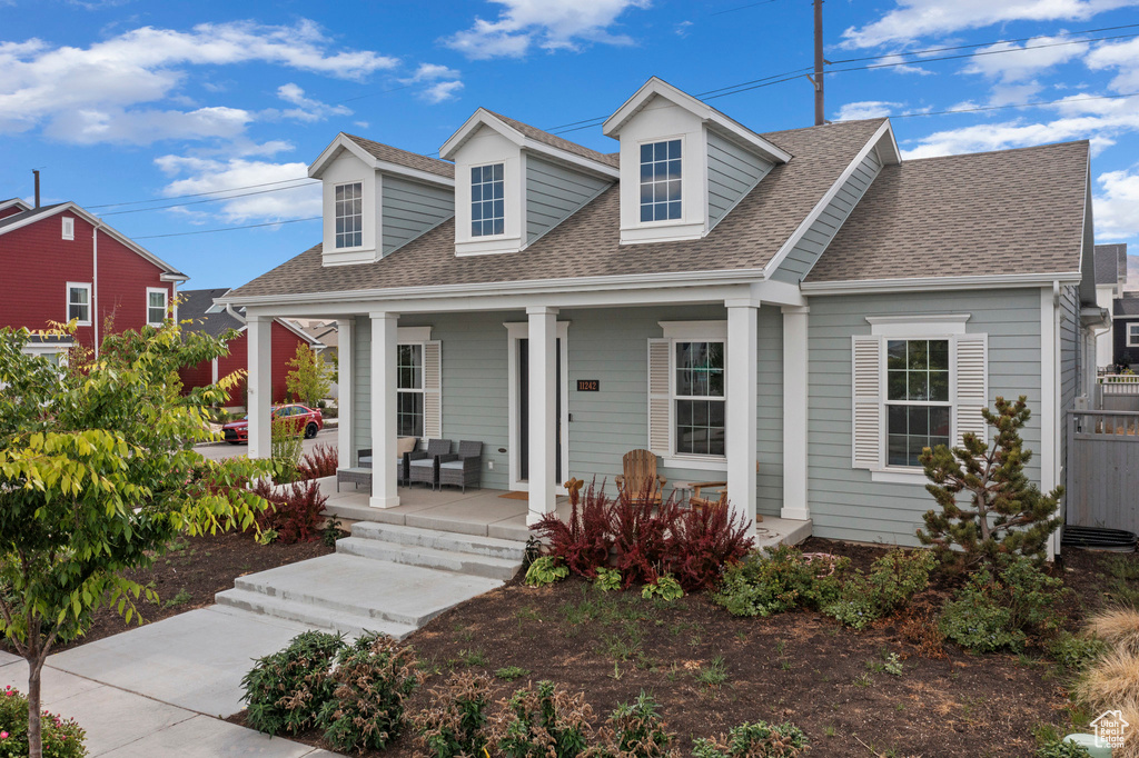 Cape cod house with roof with shingles and covered porch