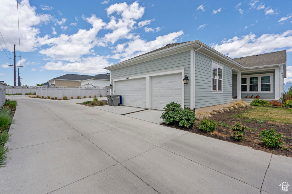 View of property exterior with driveway and an attached garage