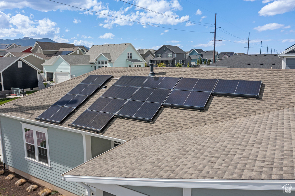 Exterior view of roof with shingles and a residential view