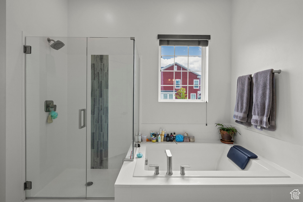 Full bath featuring a shower stall and a bath