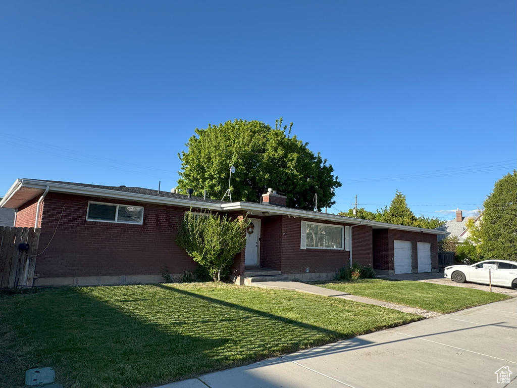 Ranch-style home with brick siding, an attached garage, concrete driveway, and a chimney