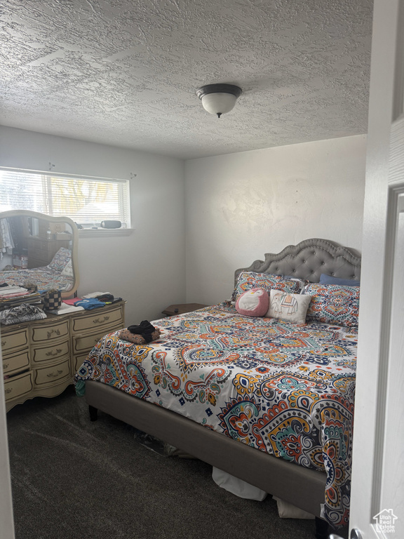 Carpeted bedroom with a textured ceiling