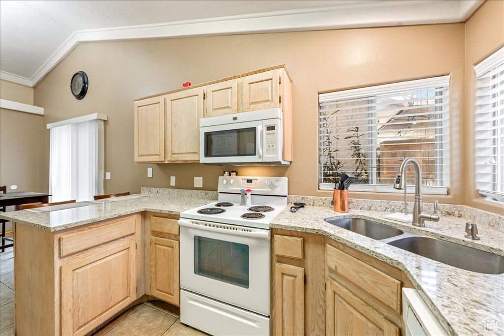 Kitchen featuring white appliances, light brown cabinetry, a sink, ornamental molding, and a peninsula