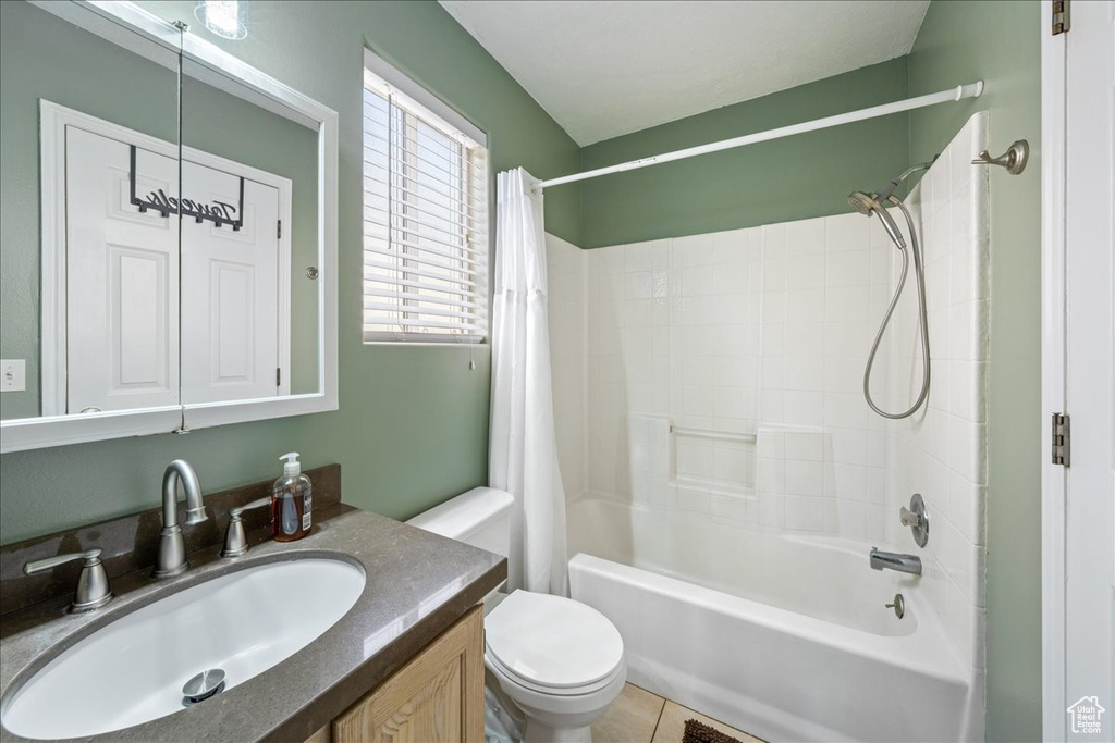 Bathroom with shower / bath combination with curtain, toilet, vanity, and tile patterned floors