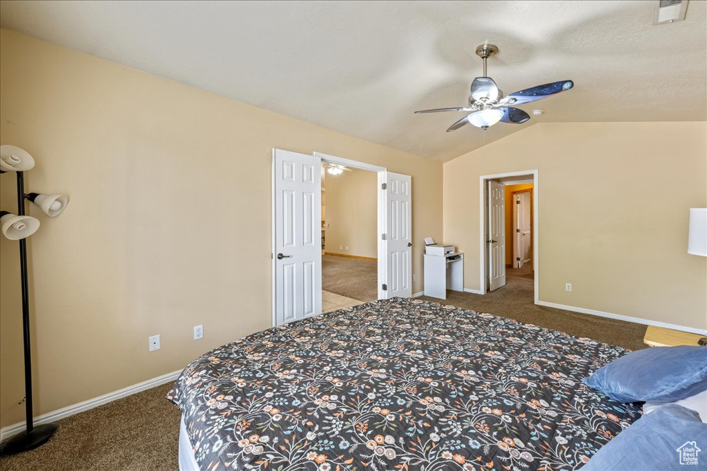 Bedroom with carpet floors, vaulted ceiling, baseboards, and ceiling fan