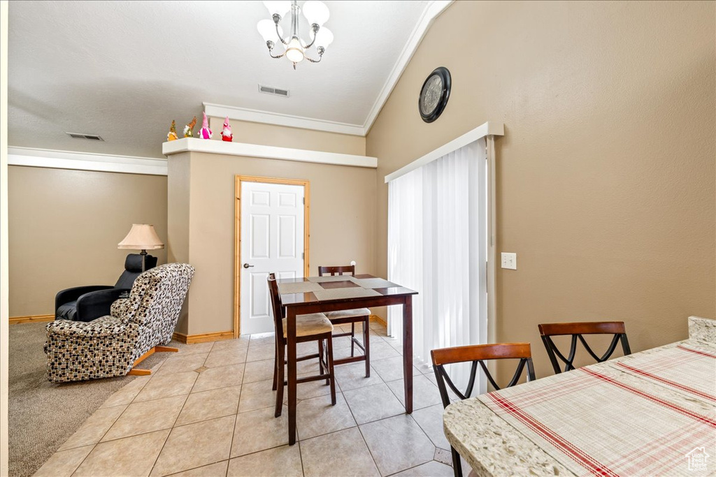 Dining space featuring crown molding, a chandelier, and light tile patterned floors