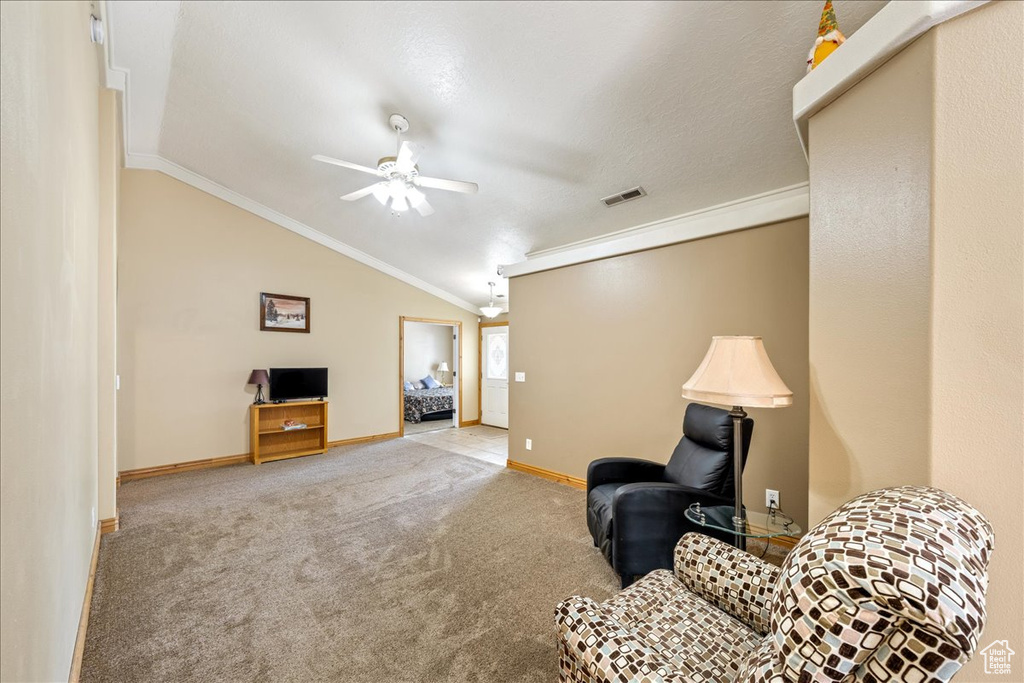 Sitting room featuring crown molding, a ceiling fan, lofted ceiling, baseboards, and carpet floors
