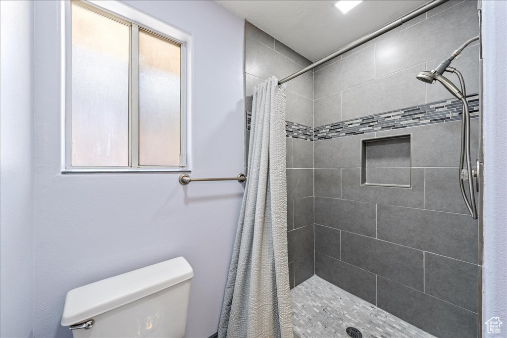 Full bathroom featuring toilet and a stall shower