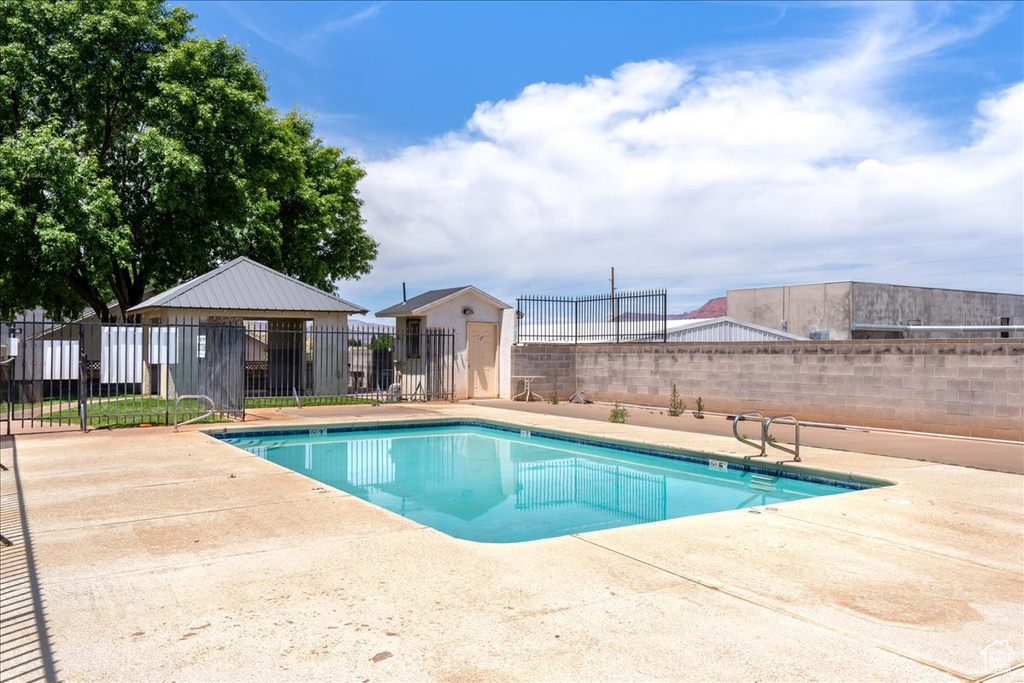 Community pool featuring a fenced backyard and a patio