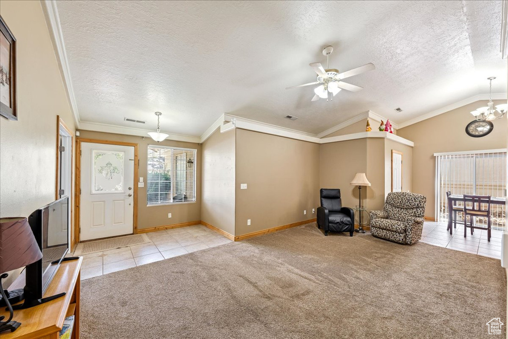 Foyer featuring light tile patterned floors, light colored carpet, a textured ceiling, a ceiling fan, and a chandelier