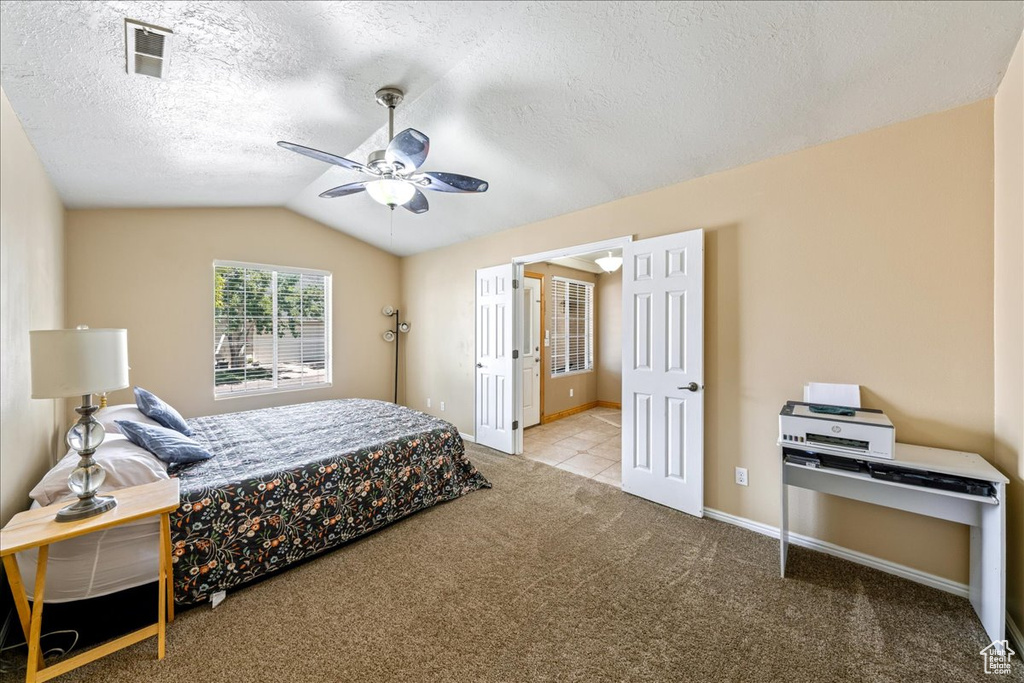 Carpeted bedroom with lofted ceiling, ceiling fan, a textured ceiling, and baseboards