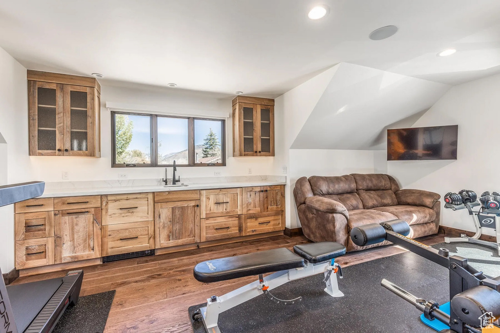 Exercise room featuring a sink, dark wood-style floors, recessed lighting, and lofted ceiling