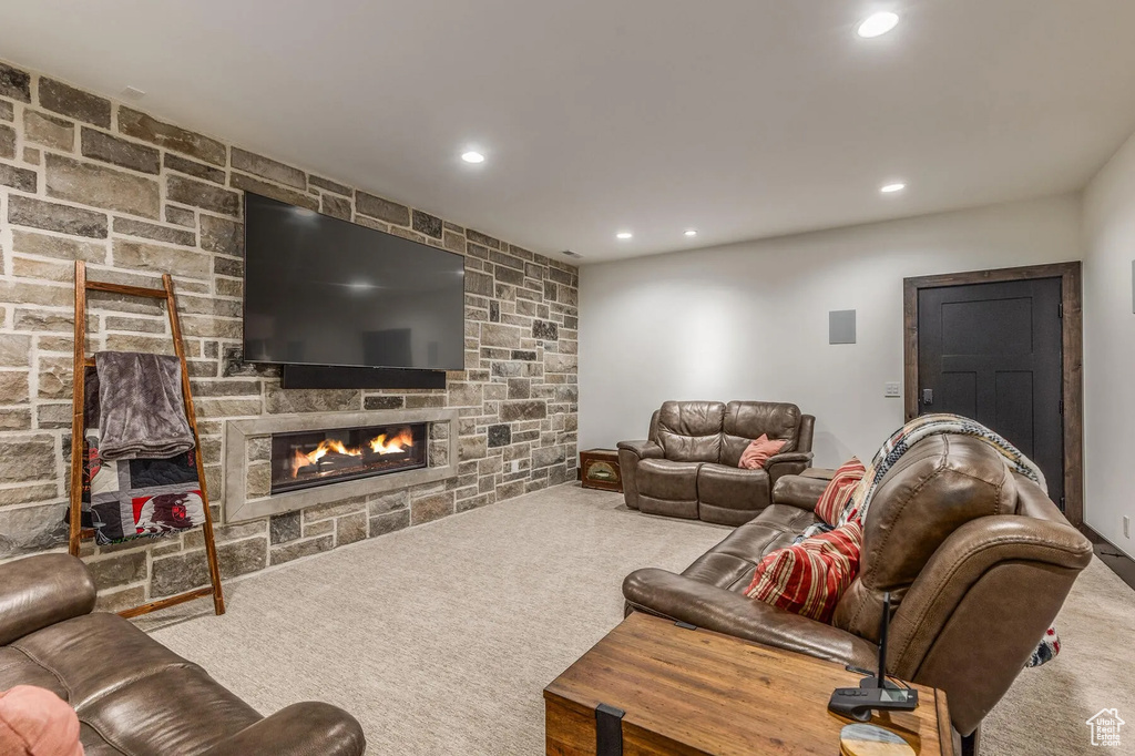 Living area featuring a stone fireplace, carpet flooring, and recessed lighting