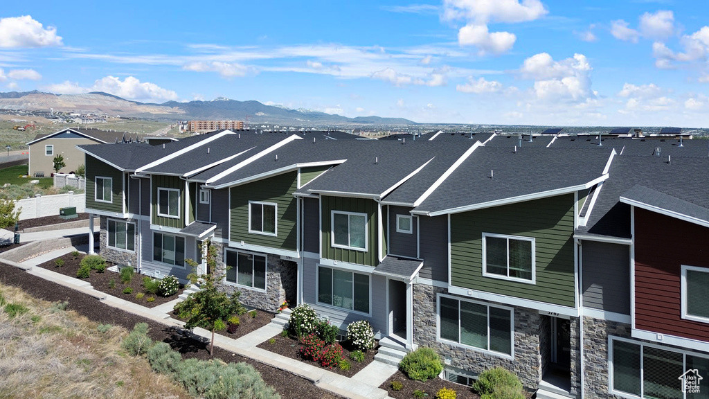 View of front of property with stone siding, a mountain view, and board and batten siding