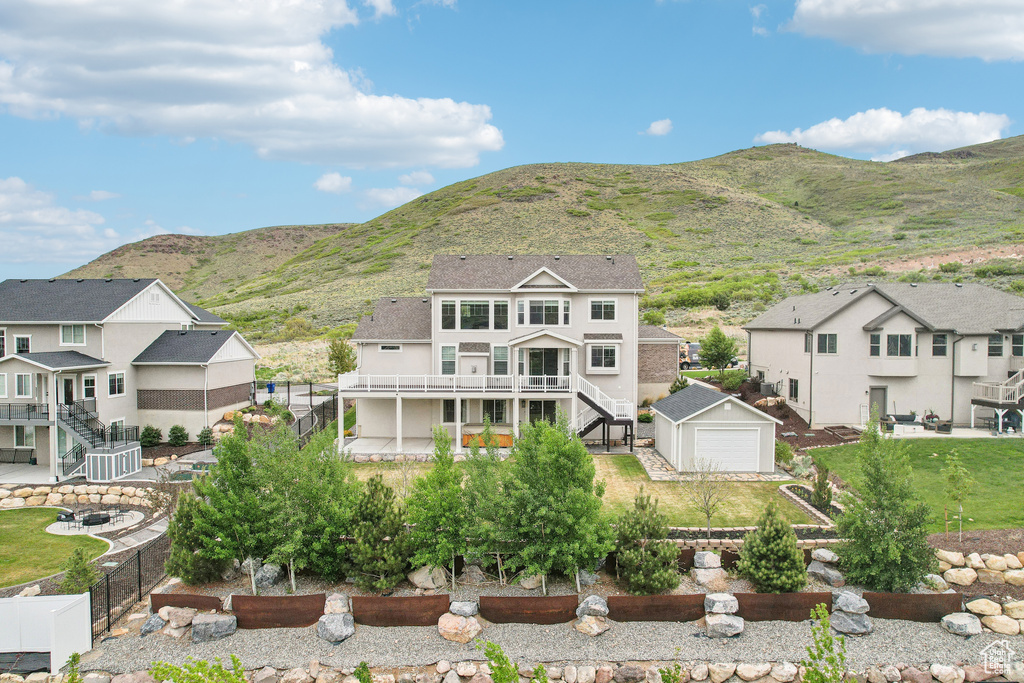 Rear view of house with stairway, a fenced backyard, an outdoor structure, a residential view, and stucco siding