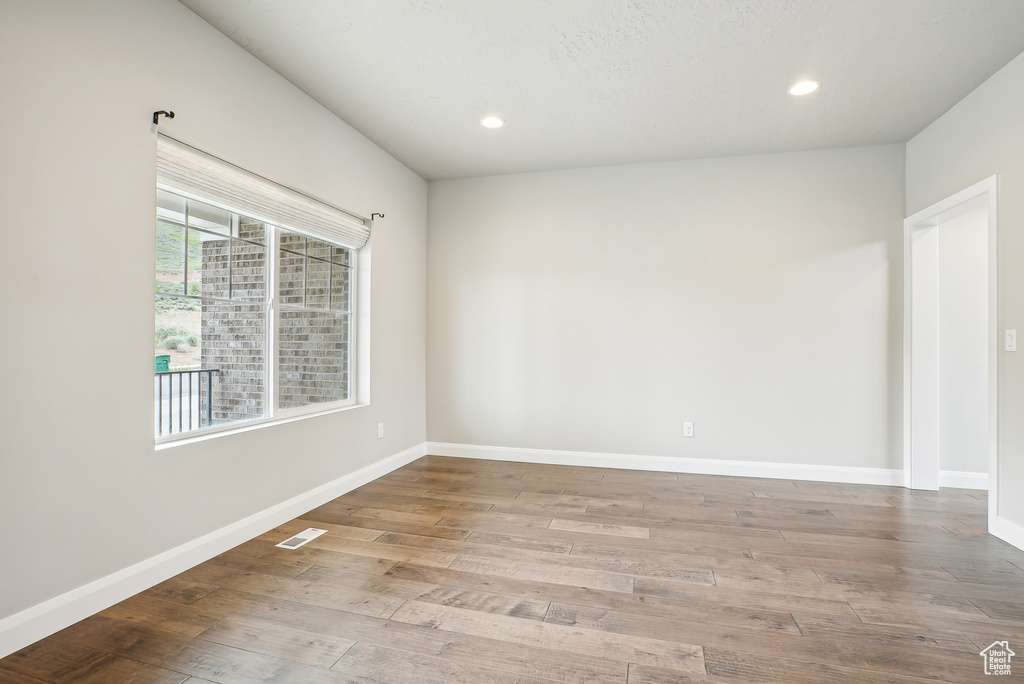 Unfurnished room with wood finished floors, recessed lighting, and baseboards