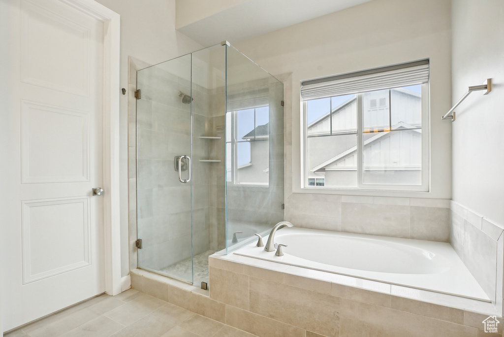 Full bath with a stall shower, a garden tub, and tile patterned flooring