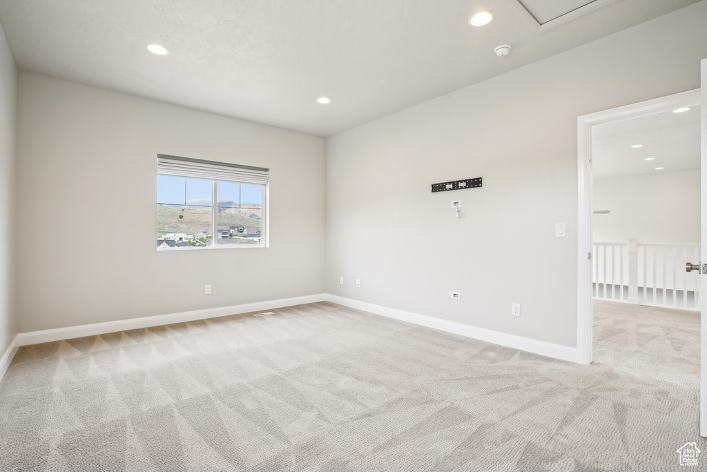 Empty room featuring light carpet, recessed lighting, and baseboards