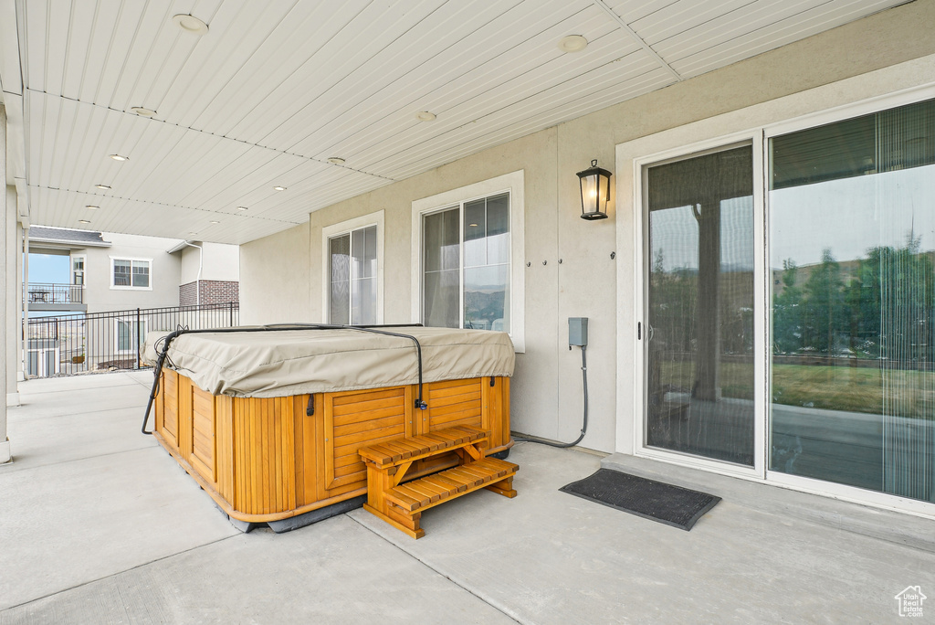 View of patio / terrace featuring a hot tub and fence