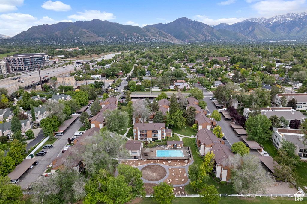 Aerial view of property's location with a mountainous background, nearby suburban area, and a pool area