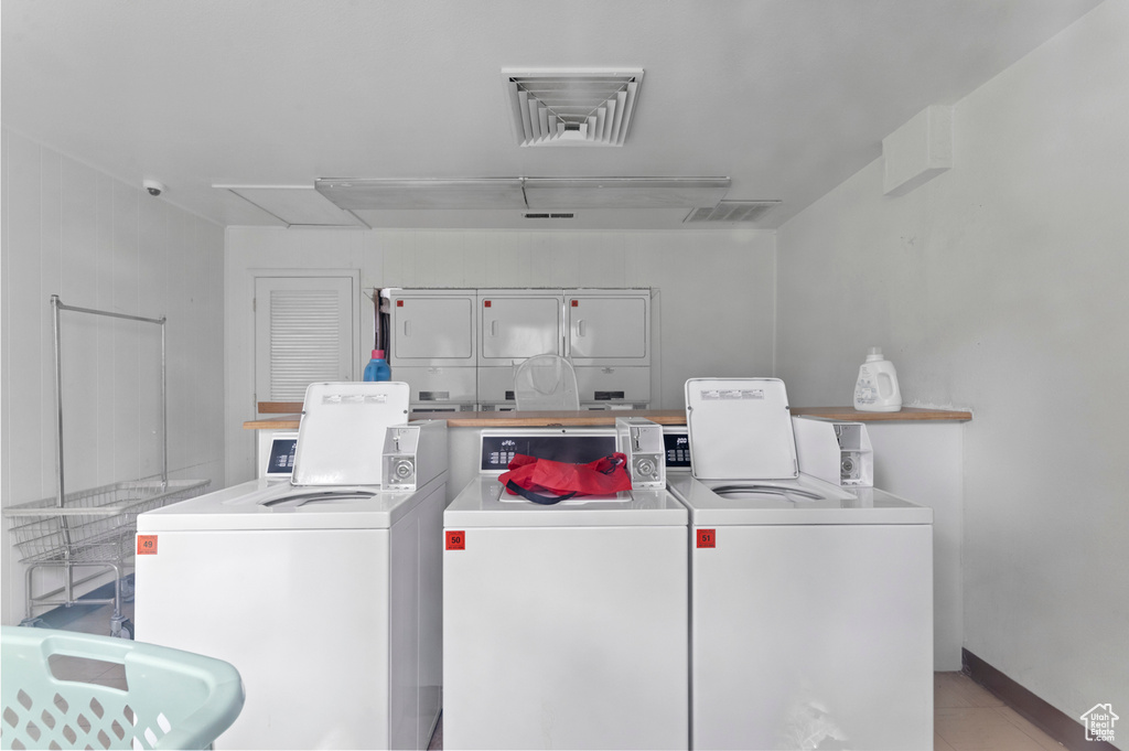 Shared laundry room with washer and dryer, attic access, and tile patterned flooring