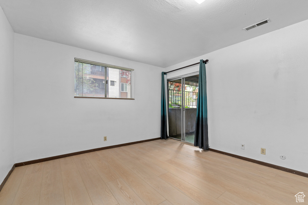 Spare room featuring light wood-type flooring and baseboards