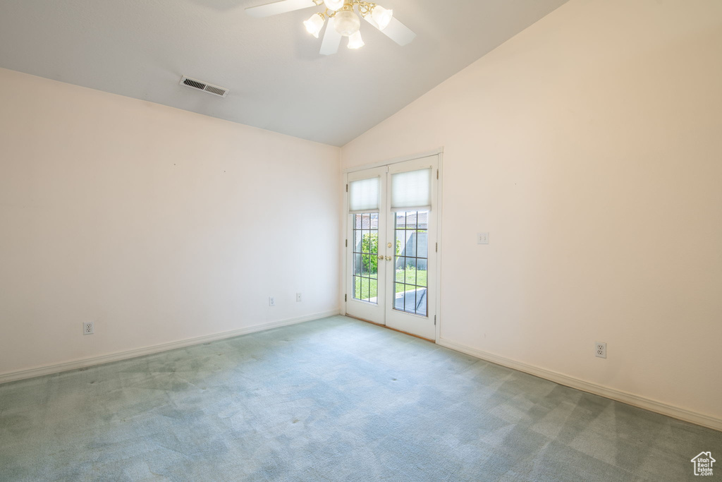 Empty room with a ceiling fan, baseboards, carpet, and high vaulted ceiling