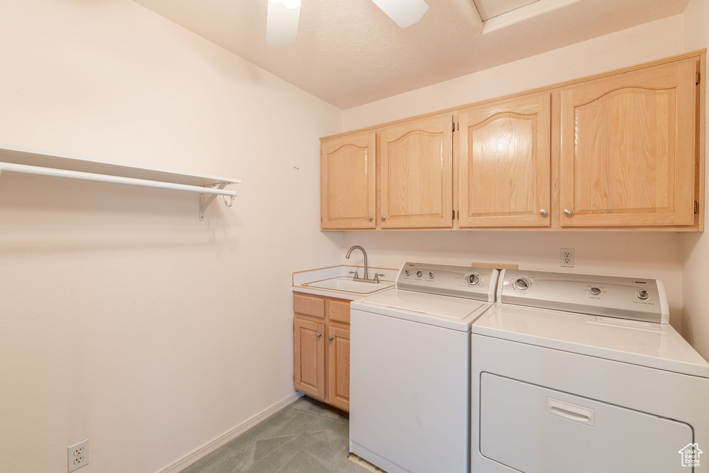 Laundry room featuring cabinet space, separate washer and dryer, baseboards, and light colored carpet